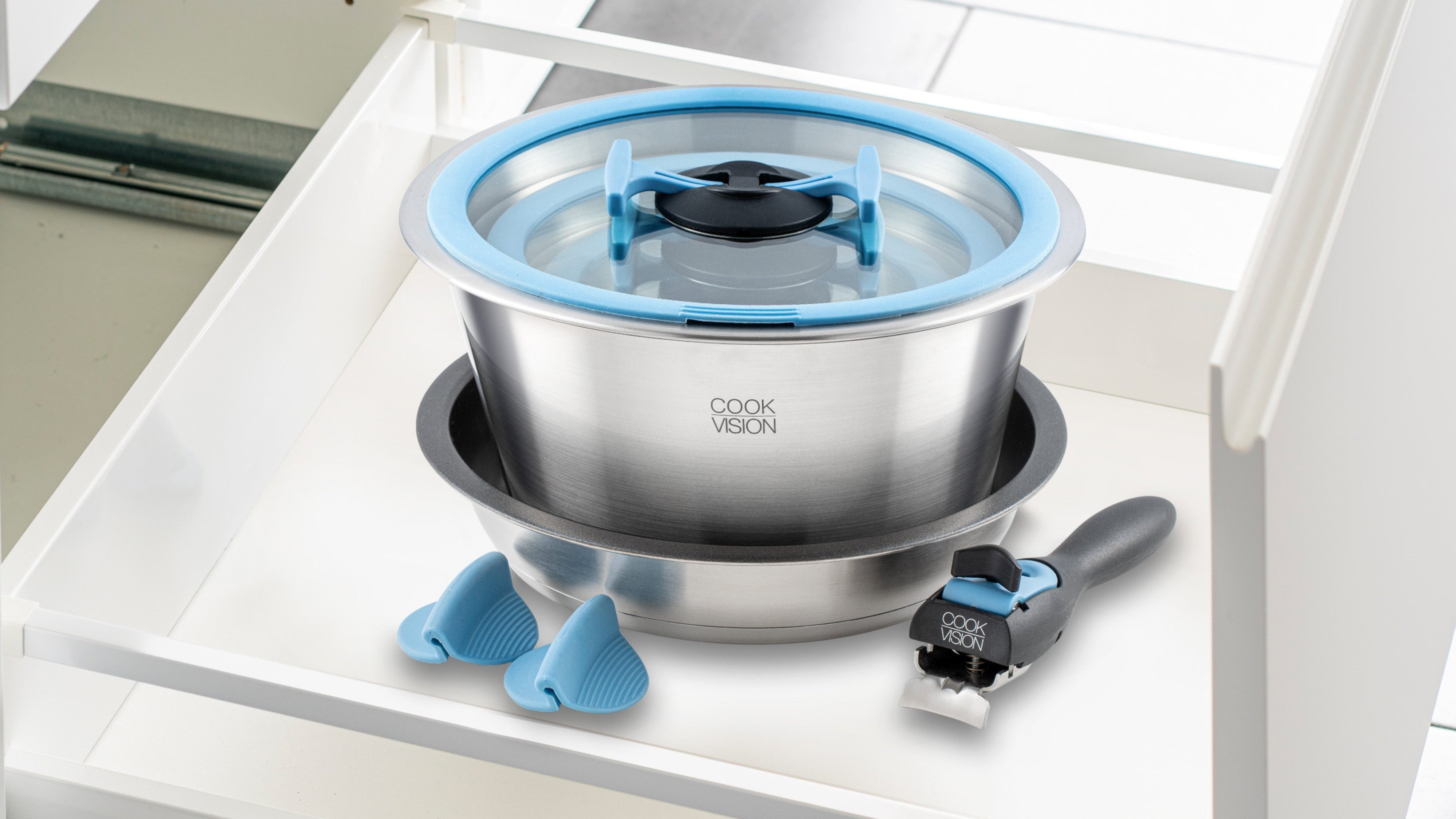 nesto Stainless steel pot with blue lid and accessories on a white surface