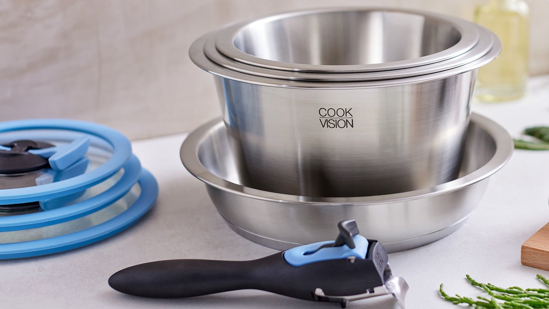 Stainless steel cookware set with 'Cook Vision' branding on a kitchen counter.