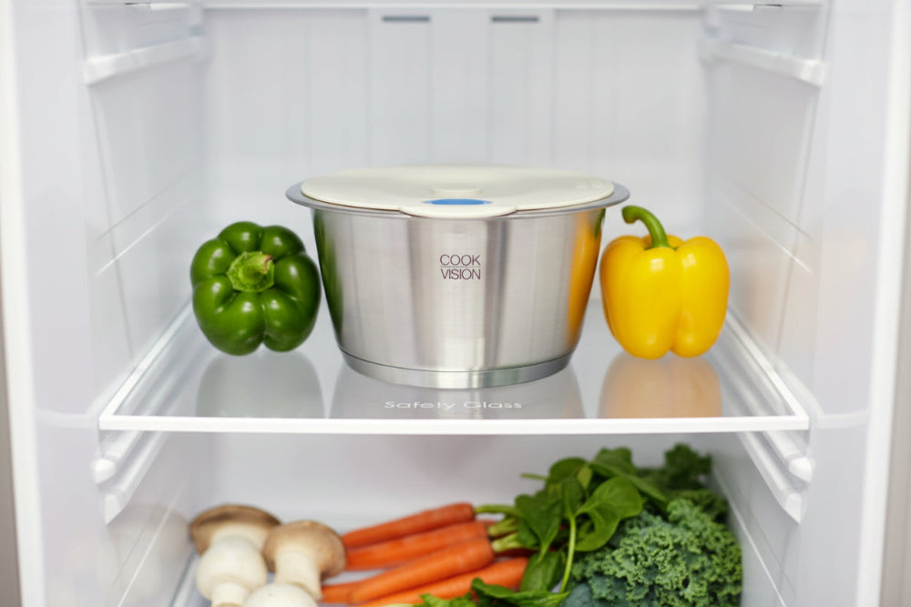 Stainless steel container with 'Cook Vision' label inside a refrigerator with vegetables.